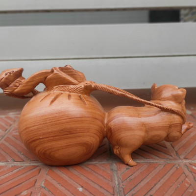 Tượng con heo kéo bao tiền bằng gỗ hương đá kt ngang 30cm